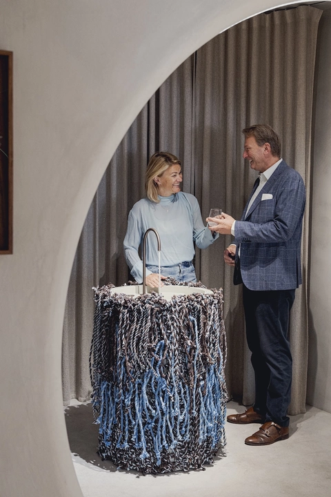 Mann und Frau unterhalten sich vor Design-Wasserspender