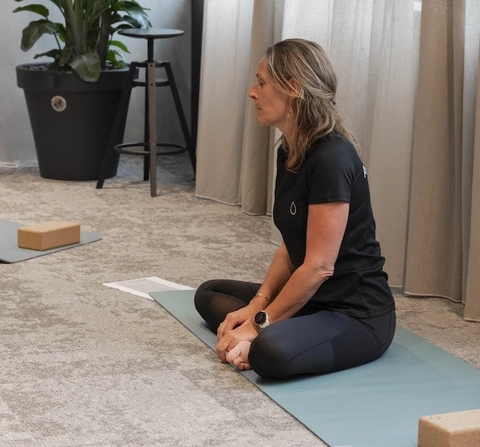 Yogaunterricht bei AQUALEX, Sophie sitzt im Schneidersitz vor Gruppe